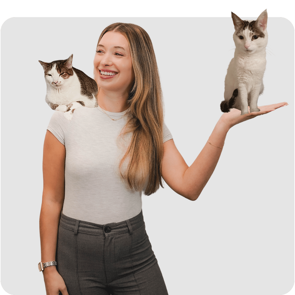a woman standing next to a cat